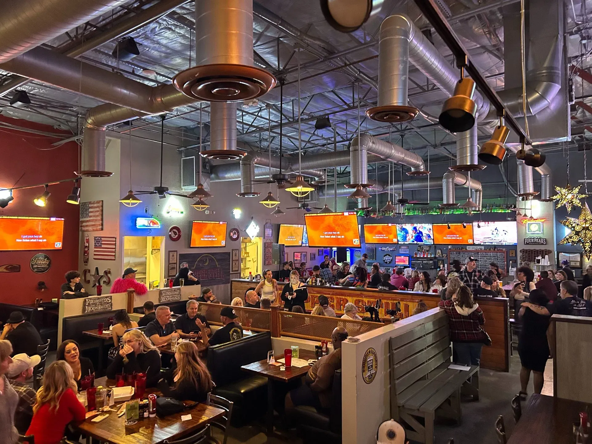 Busy Copper Still sports grill interior with guests, bar seating and game-day TVs